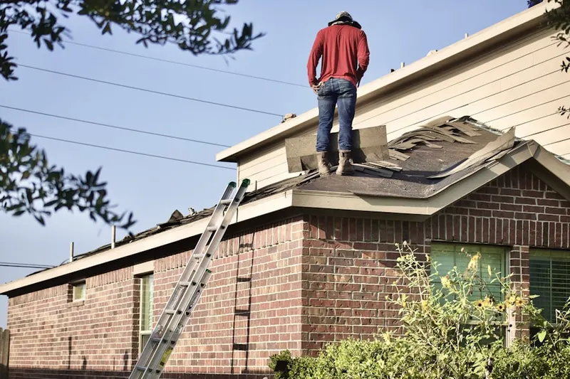Professional roofer working on a residential roof in Friendship Manor